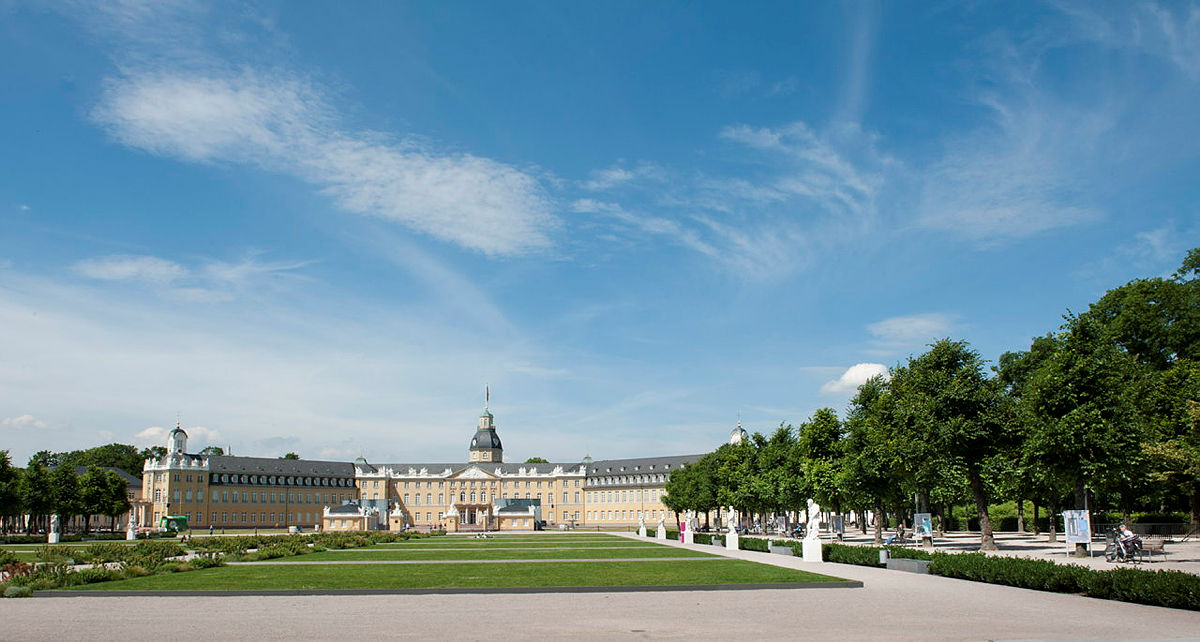 Historic palace with green dome and terraced garden.